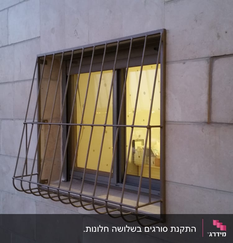 חלון עם סורגים על קיר אבן חיצוני